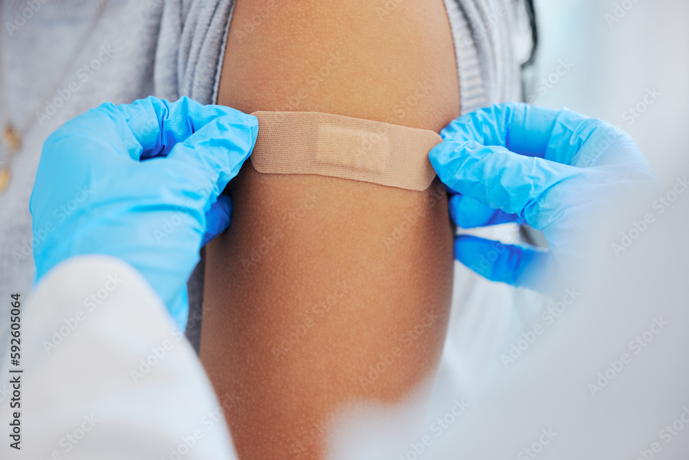 Fototapeta premium Person, arm closeup and covid with a plaster and hands for healthcare and medical injection. Patient and doctor at a clinic or hospital for vaccine with a bandage for virus, health and wellness shot