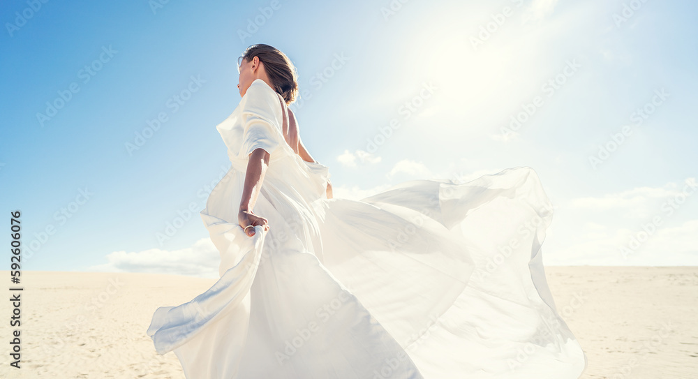 Calm woman in fashionable, maxi white wedding dress posing on the desert, dancing in sunny light Calm woman in fashionable, maxi white wedding dress posing on the desert, dancing in sunny light