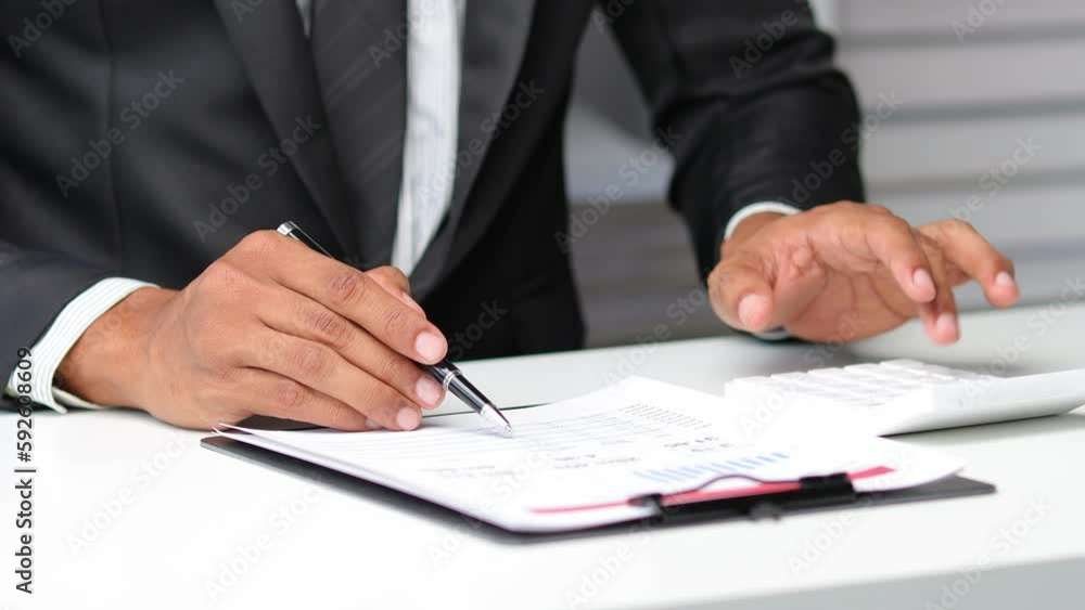 Businessman working on financial documents on desk in office. Budget analysis and financial planning. Businessman working on financial documents on desk in office. Budget analysis and financial planning.