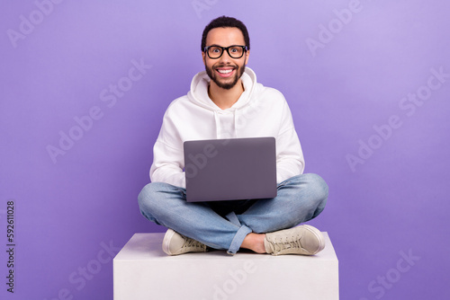 Full body photo of excited surprised man sit box platform using apple macbook eshopping proposition isolated on purple color background