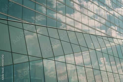 Closeup shot of the clouds reflected on glass windows of the modern building on a sunny day