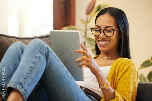 Fotografija Tablet, relax and woman reading in home living room on sofa, social media or ebook
