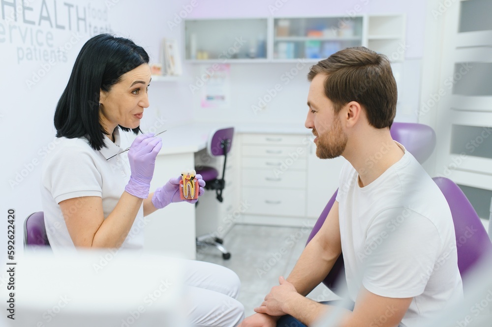 Sad man sitting in dental chair suffering from acute tooth pain, rubbing his cheek, close up. Sad man sitting in dental chair suffering from acute tooth pain, rubbing his cheek, close up.