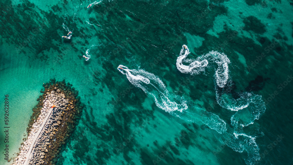 Aerial view on motorboat and jetski on the sea surface.