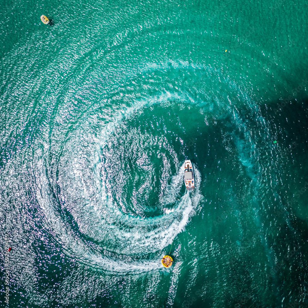 Aerial view on motorboat and jetski on the sea surface.