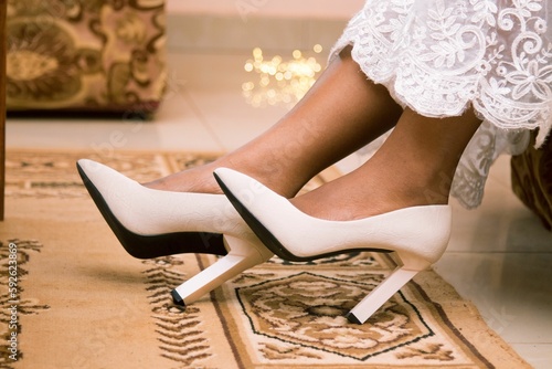 Closeup of bride's feet with white heels