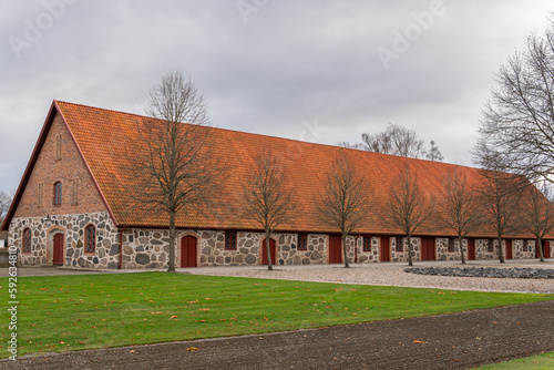 An old ancient building in Scandinavian style from big stones and bricks. Rural area, village, big farm.