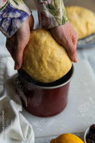 Step by step process of making sweet Easter bread. Woman puts a sweet bread (Ukrainian Easter bread paska) into special springform pan. photo