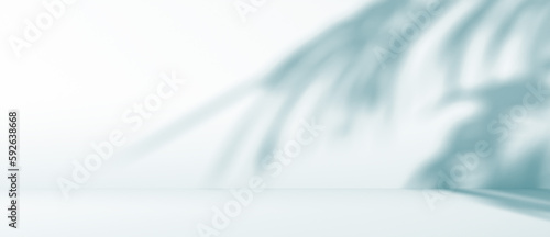 blurred shadow of palm leaves on a blue wall. Abstract minimal background for a product presentation. Summer and spring seasons, texture for a display photo