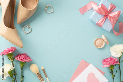 Charming top view flat lay photo of high-heels, earrings, makeup brushes, a gift box, and carnation flowers with a postcard on a pastel blue background with empty space