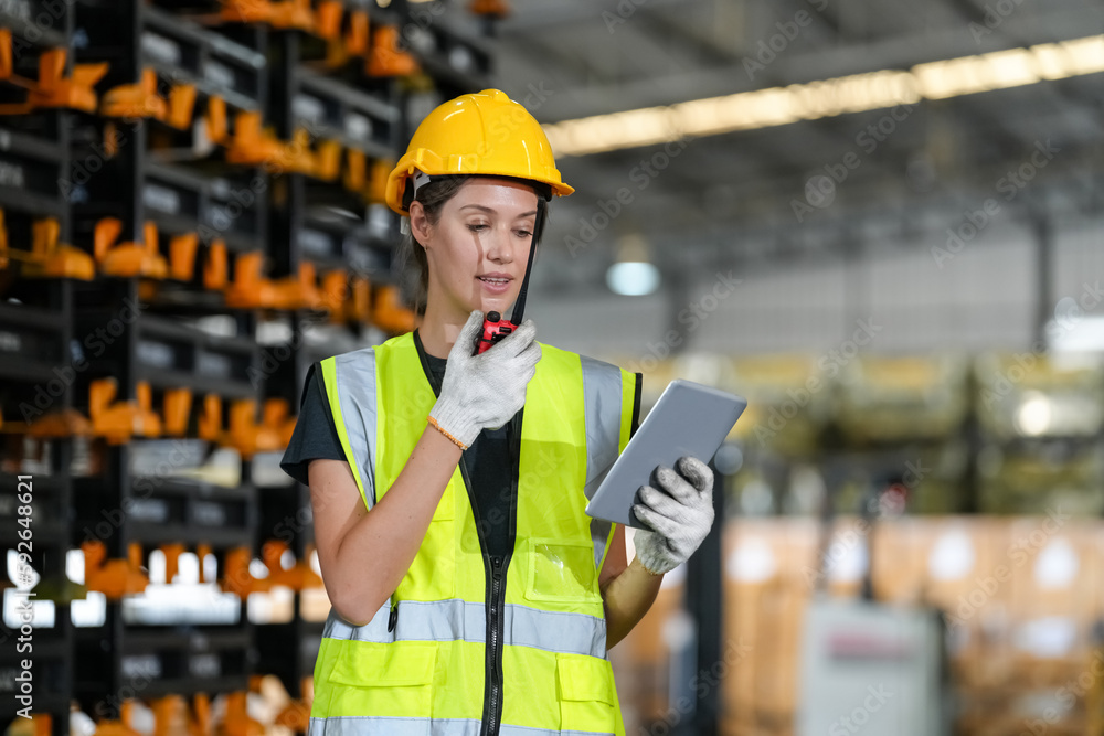 Multiethnic industrial workers checking their logistic lists while working with transportation of goods in warehouse Multiethnic industrial workers checking their logistic lists while working with transportation of goods in warehouse