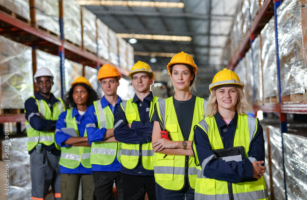 Multiethnic industrial workers checking their logistic lists while working with transportation of goods in warehouse Multiethnic industrial workers checking their logistic lists while working with transportation of goods in warehouse