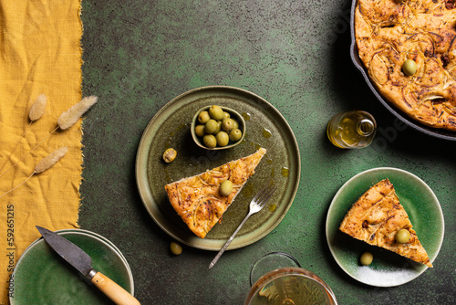 Delicious focaccia bread piece with green olives served on plate photo