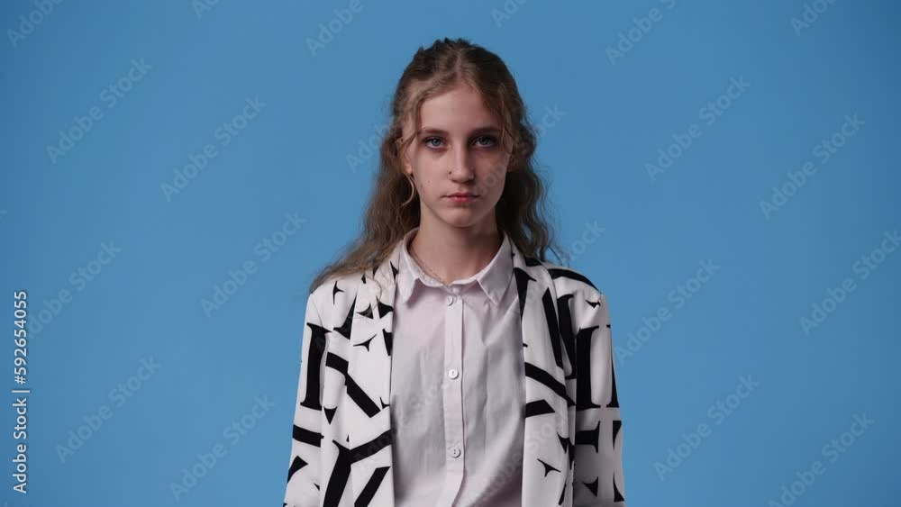 4k video of one girl who showing the hand sign for silence over blue background. 4k video of one girl who showing the hand sign for silence over blue background.