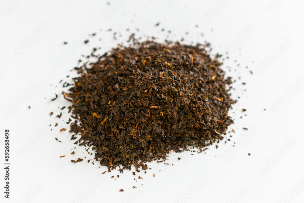 Ceylon black tea.. Scattered black tea on a white background. Isolated. Close up. Dried herbs. Top view. Ceylon black tea.. Scattered black tea on a white background. Isolated. Close up. Dried herbs. Top view.