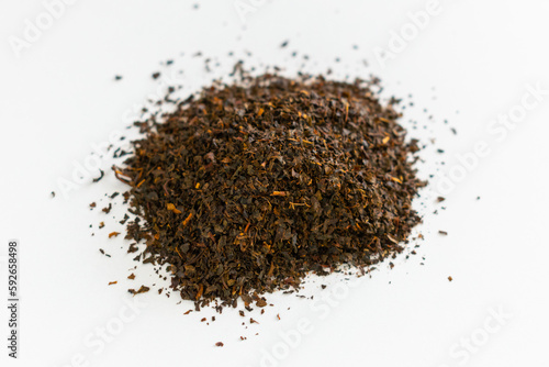 Ceylon black tea.. Scattered black tea on a white background. Isolated. Close up. Dried herbs. Top view.
