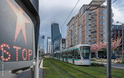 Εκτύπωση καμβά Courbevoie, France - 04 12 2023: View of La Defense district from the tramway track with a tramway and a red stop pedestrian sign