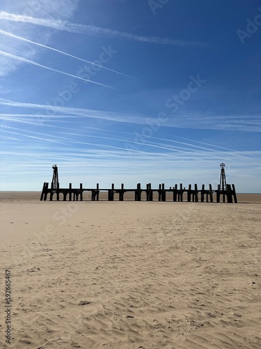 Old wooden pier On St Anne's beach in Lytham Lancashire England. Blue sky background and no people. 