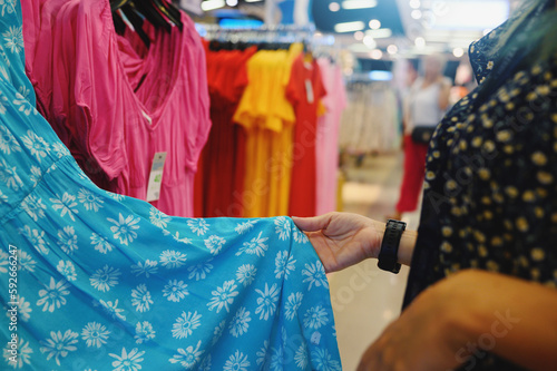 Woman selects a woman dress in a store