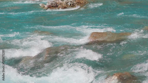 4K shot of Tsarap river flowing with so many rocks in between obstructing the flow of river as seen during the trek to the Phugtal monastery near Purne in Zanskar Valley, Ladakh, India.  photo