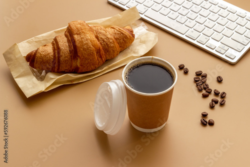 Fototapeta Naklejka Na Ścianę i Meble -  Coffee break in the office. Paper cup of coffee with keyboard, top view