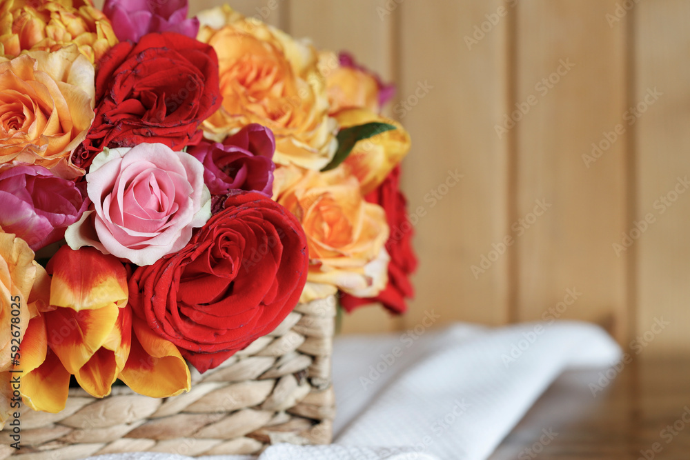 Roses and tulips in wicker basket. Decoration on the table. Roses and tulips in wicker basket. Decoration on the table.