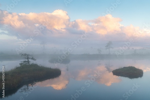 Beautiful shot of a fog over the calm lake at sunset