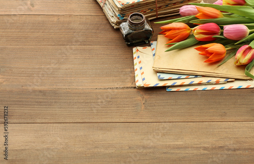 Colorful tulips and vintage letters on wooden background, copy space.