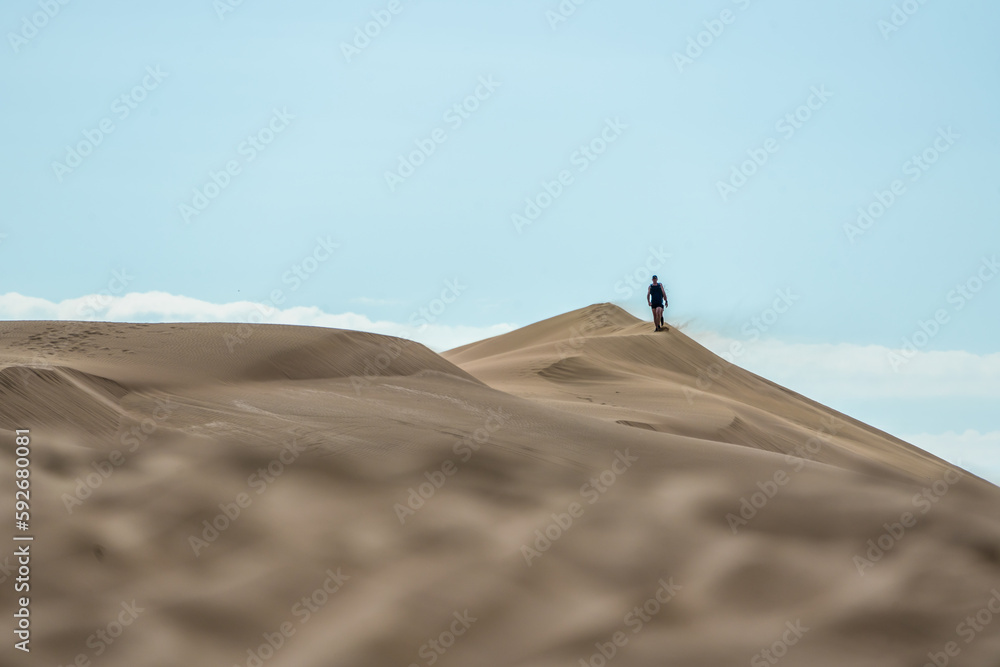 Hiker among sand dunes in the desert. 