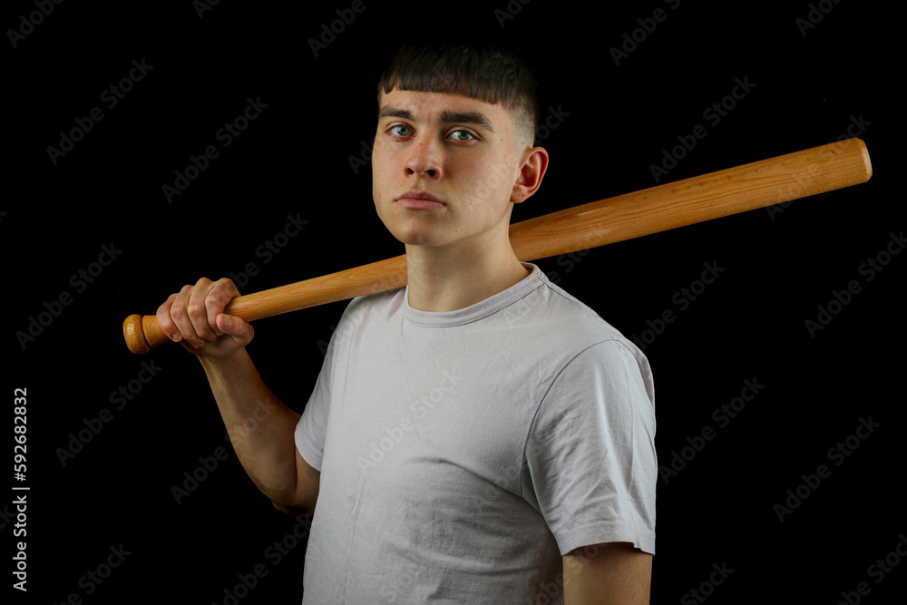 Teen boy with a baseball bat black background Teen boy with a baseball bat black background