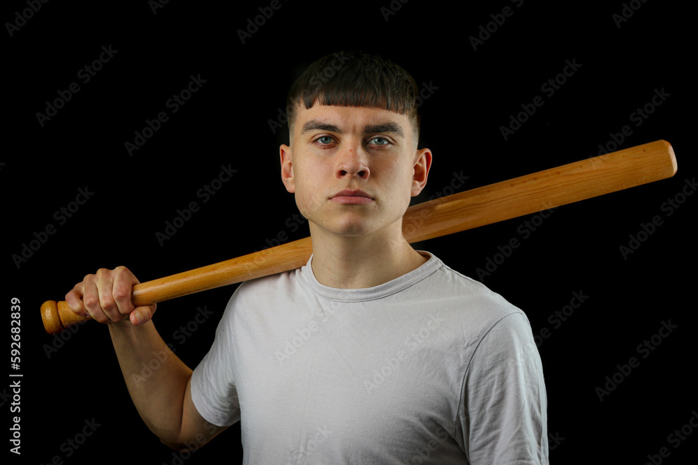 Teen boy with a baseball bat black background Teen boy with a baseball bat black background