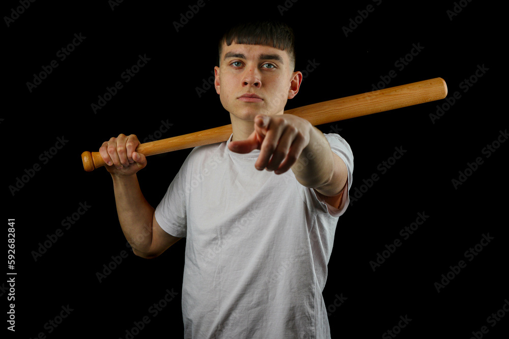 Teen boy with a baseball bat black background Teen boy with a baseball bat black background