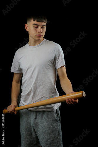 Teen boy with a baseball bat black background