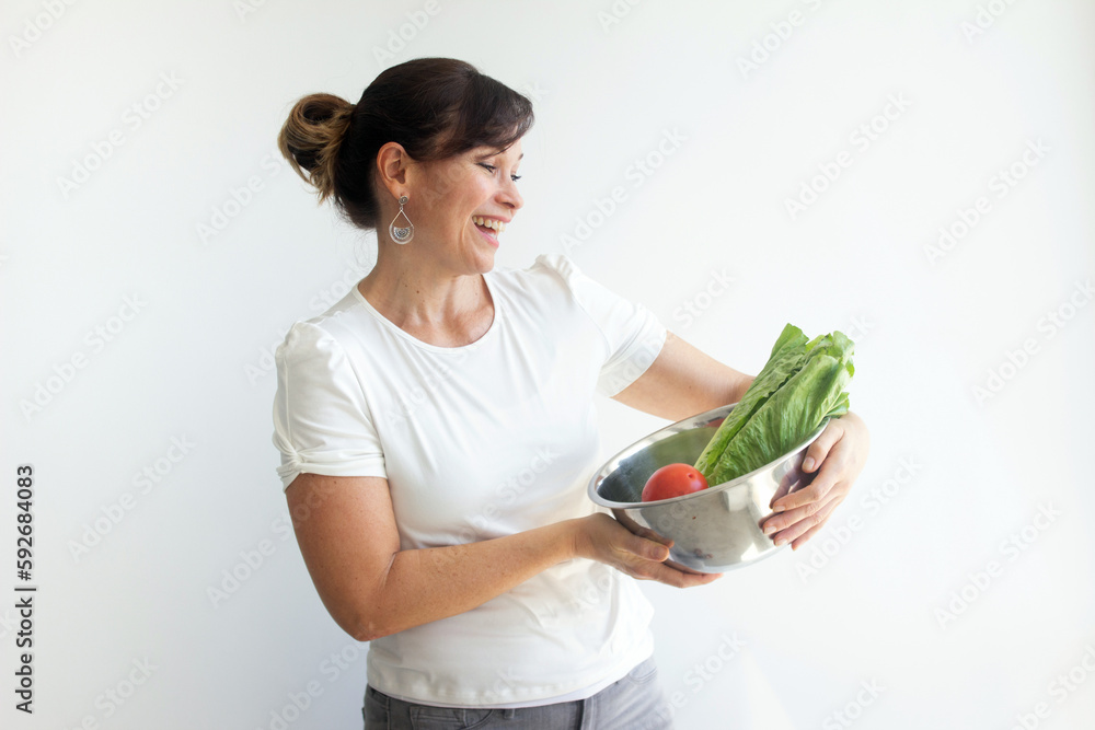 Beautiful latin woman holding fresh greens vegetables. On a diet for healthy eating, isolated on a white background. Beautiful latin woman holding fresh greens vegetables. On a diet for healthy eating, isolated on a white background.