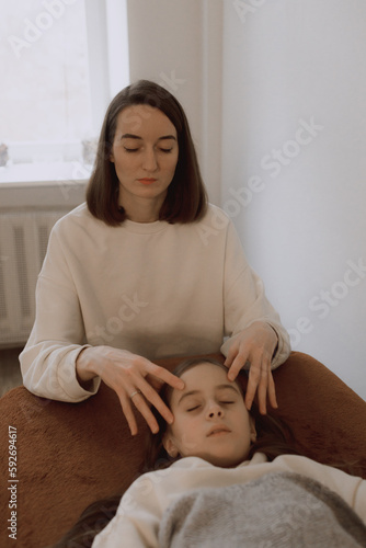 Female energy massage relaxing and care treatment for body and mindfull health gentle woman arms holding head doing access bars and face young procedure. photo