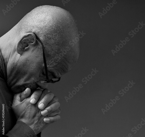 praying to god with hands together Caribbean man praying with black background stock photos stock photo 