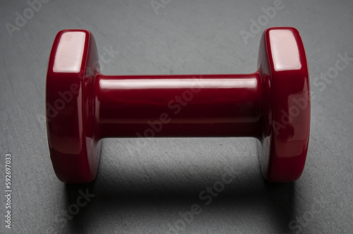 Red dumbbell close up on a black background