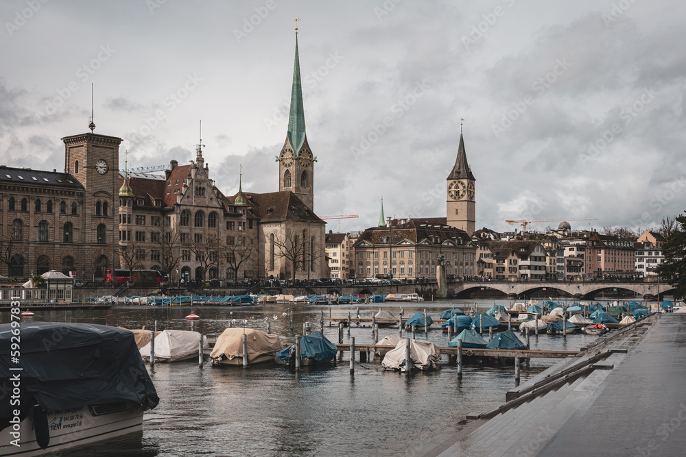 Fraumunster church in Zurich city Switzerland. Riverside view, boats parked on the river, Bridge in the distance, daytime, no recognizable people