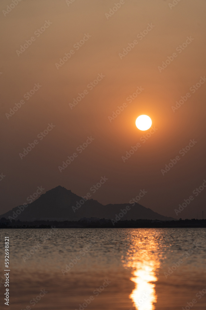 Beautiful Sunset by the lake and mountains with reflection Beautiful Sunset by the lake and mountains with reflection