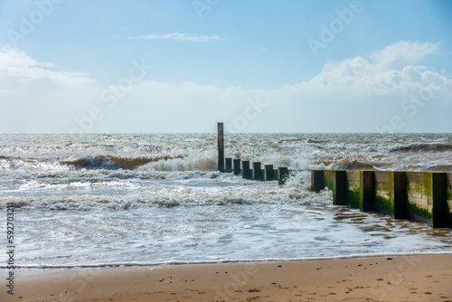 A groyne reaching out into the sea  perpendicular to the shoreline on Durley Chine Beach  Bournemouth  UK to prevent long shore drift