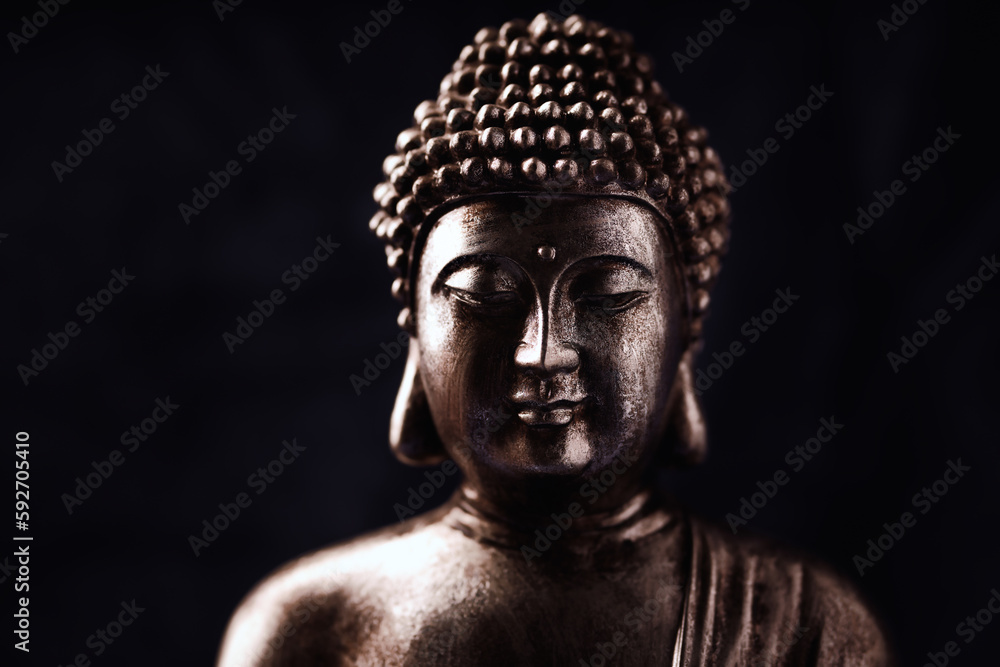 Meditating Buddha Statue on dark background. Soft focus. Close up. Copy space.	