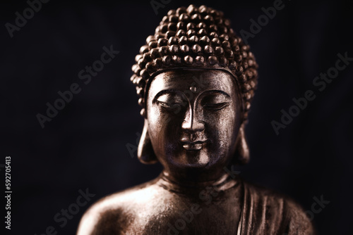 Meditating Buddha Statue on dark background. Soft focus. Close up. Copy space. 
