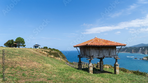 Paisaje típico de la costa asturiana, con un verde prado y hórreo en Cadavedo, España.