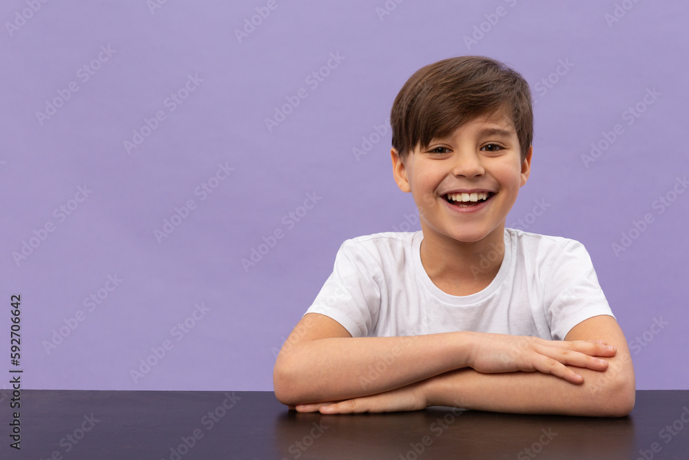 Happy schoolboys sitting at desk, classroom. Violet background Happy schoolboys sitting at desk, classroom. Violet background