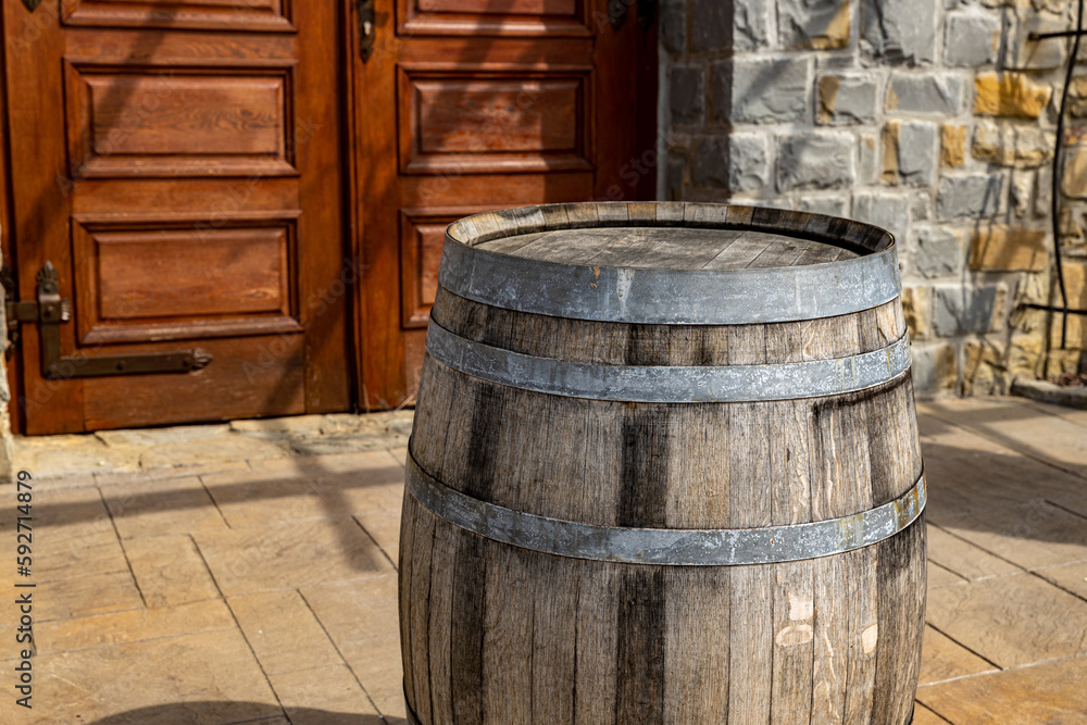 Wine barrel near the carved door of the winery Wine barrel near the carved door of the winery