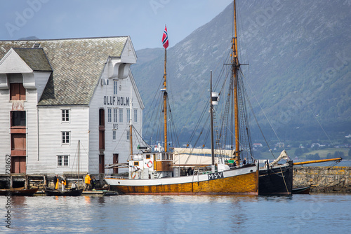 Historic sailing boats parking at an old dock in the city of Ålesund in Norway photo