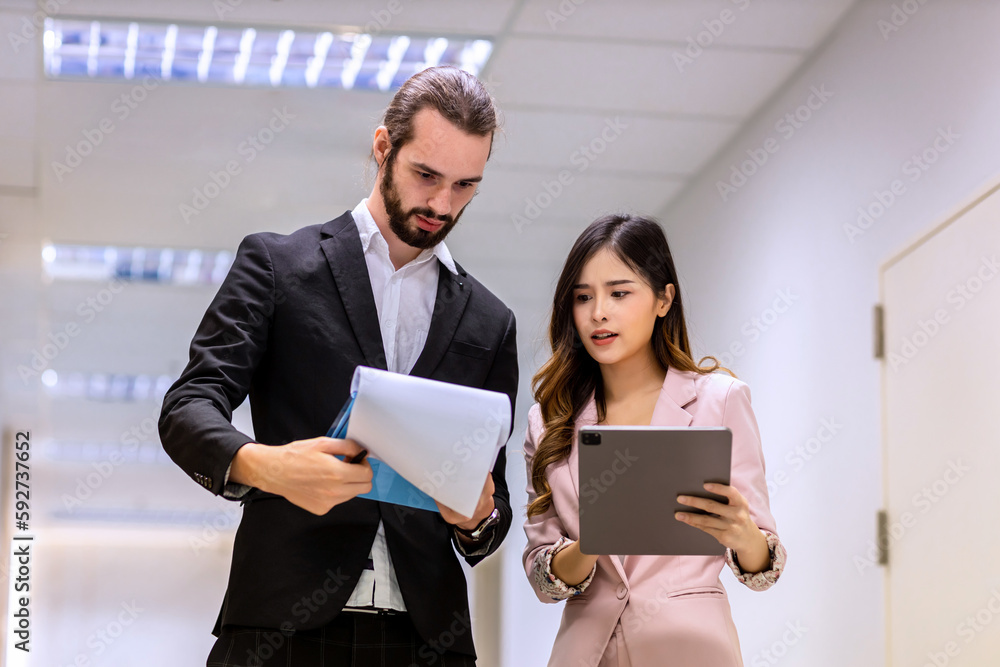 Diverse friend partners colleagues talking walking in modern office hallway. Confident business partners walking down in office building and talking. Professional business people walking and talking Diverse friend partners colleagues talking walking in modern office hallway. Confident business partners walking down in office building and talking. Professional business people walking and talking