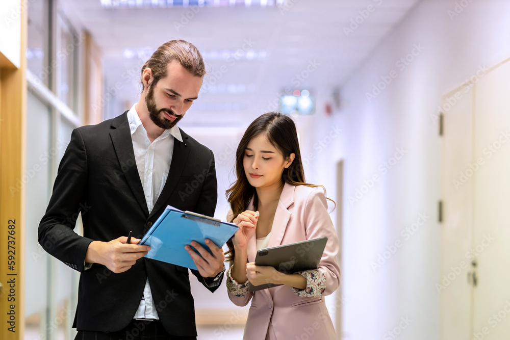 Diverse friend partners colleagues talking walking in modern office hallway. Confident business partners walking down in office building and talking. Professional business people walking and talking Diverse friend partners colleagues talking walking in modern office hallway. Confident business partners walking down in office building and talking. Professional business people walking and talking
