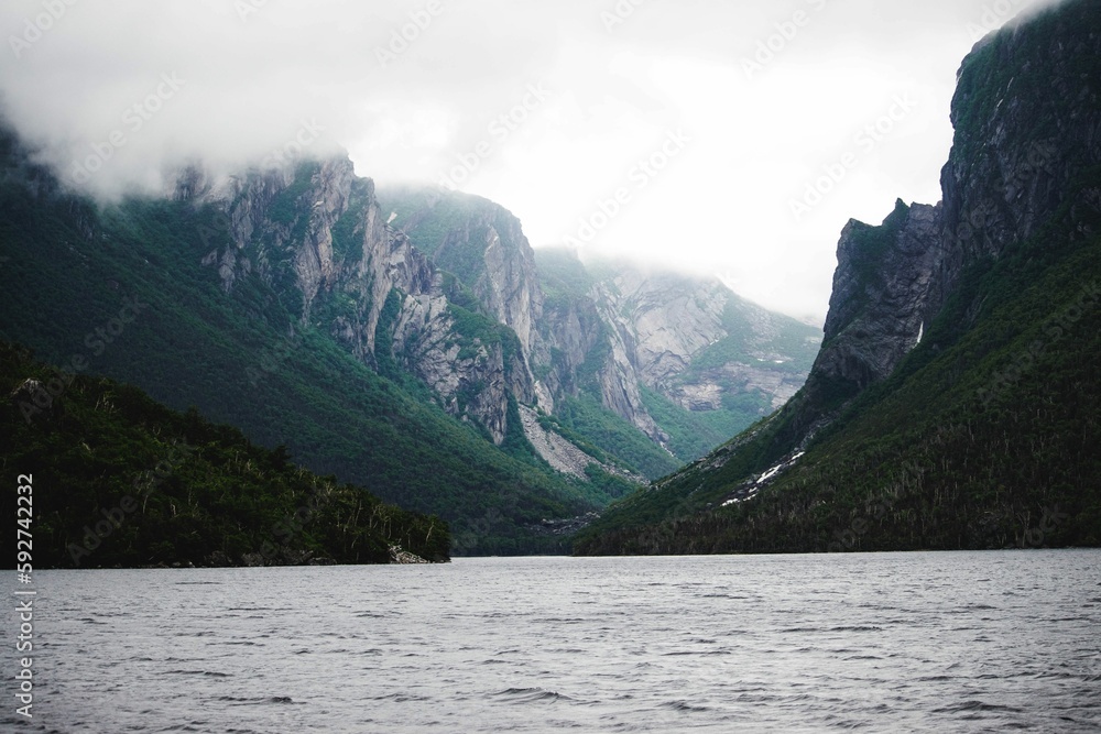 Beautiful shot of cliffs in Western Brook Pond with fog