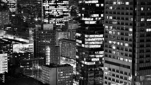 View of at night glass buildings and modern business skyscrapers . View of modern skyscrapers and  business buildings in downtown. Big city at night. Black and white.